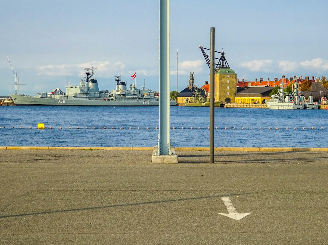 Cars and passengers waiting in line to board a ferry at a Danish harbor