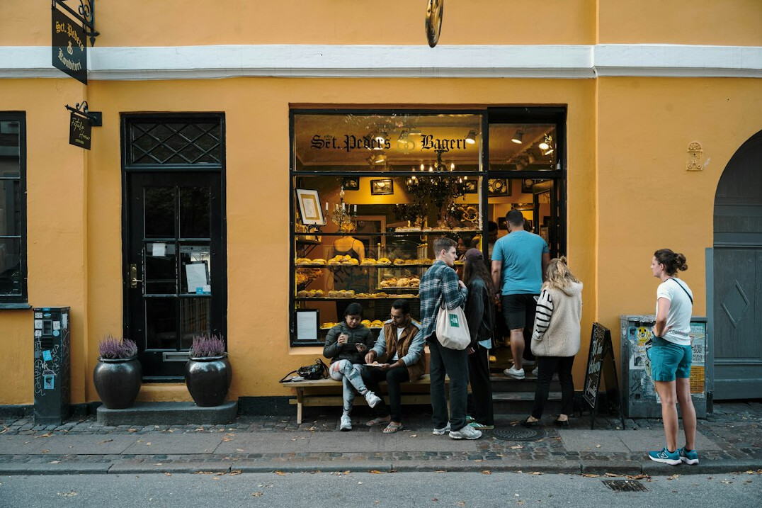 People standing in a morning queue outside a small Danish bakery