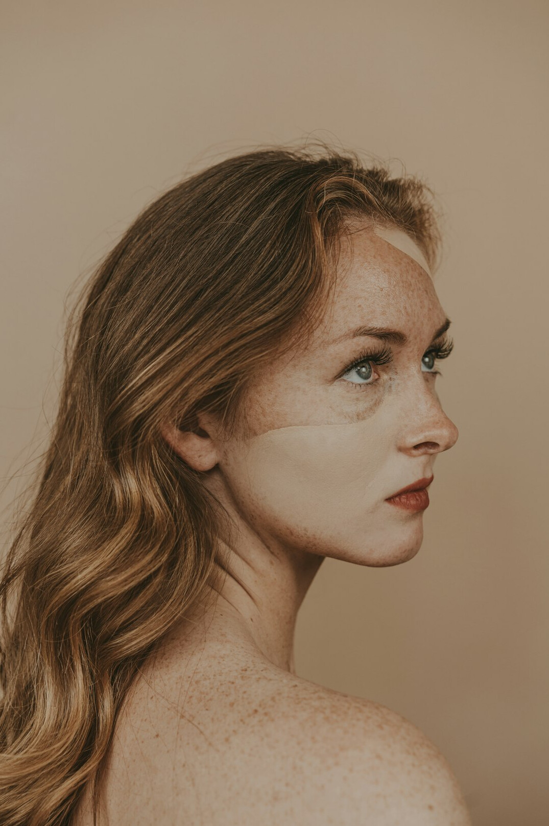Side profile portrait of a young woman looking upward thoughtfully